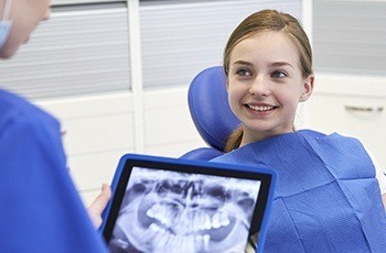 Smiling child in dental chair during wisdom tooth examination