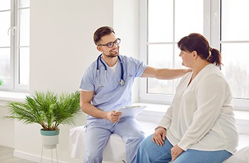 Friendly doctor talking to obese patient