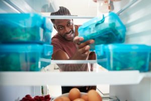 person taking food out of their refrigerator