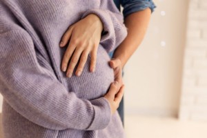 Close up of couple rubbing baby bump